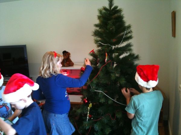 Kids putting up the christmas tree.